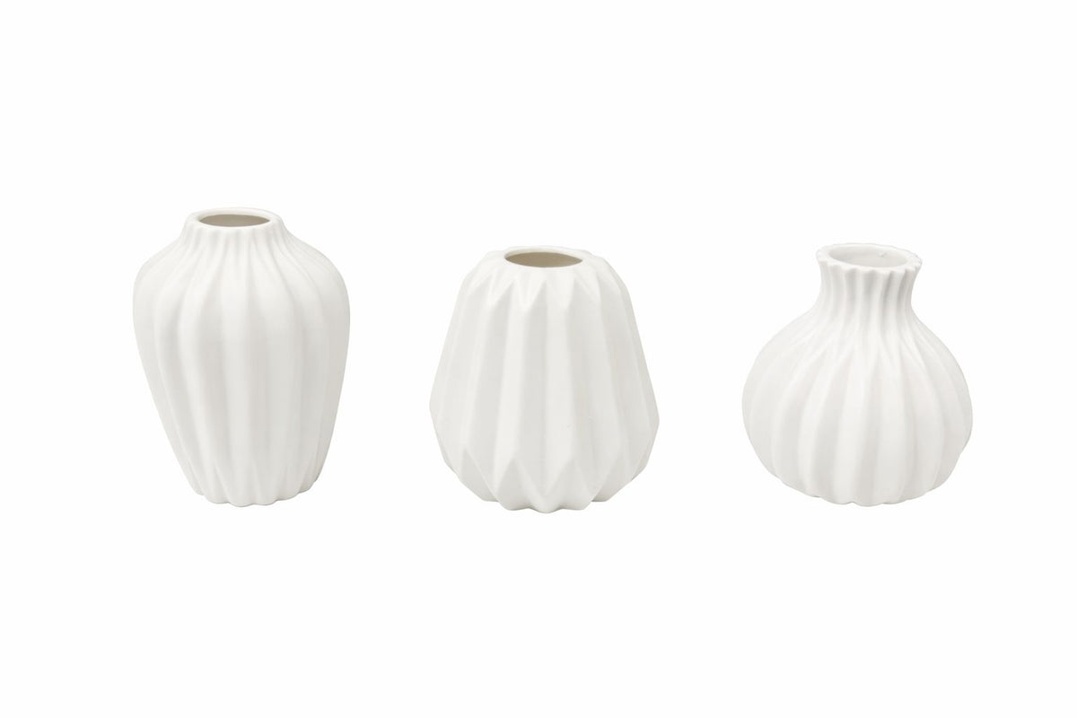 Three white porcelain ribbed vases arranged together with textured sides