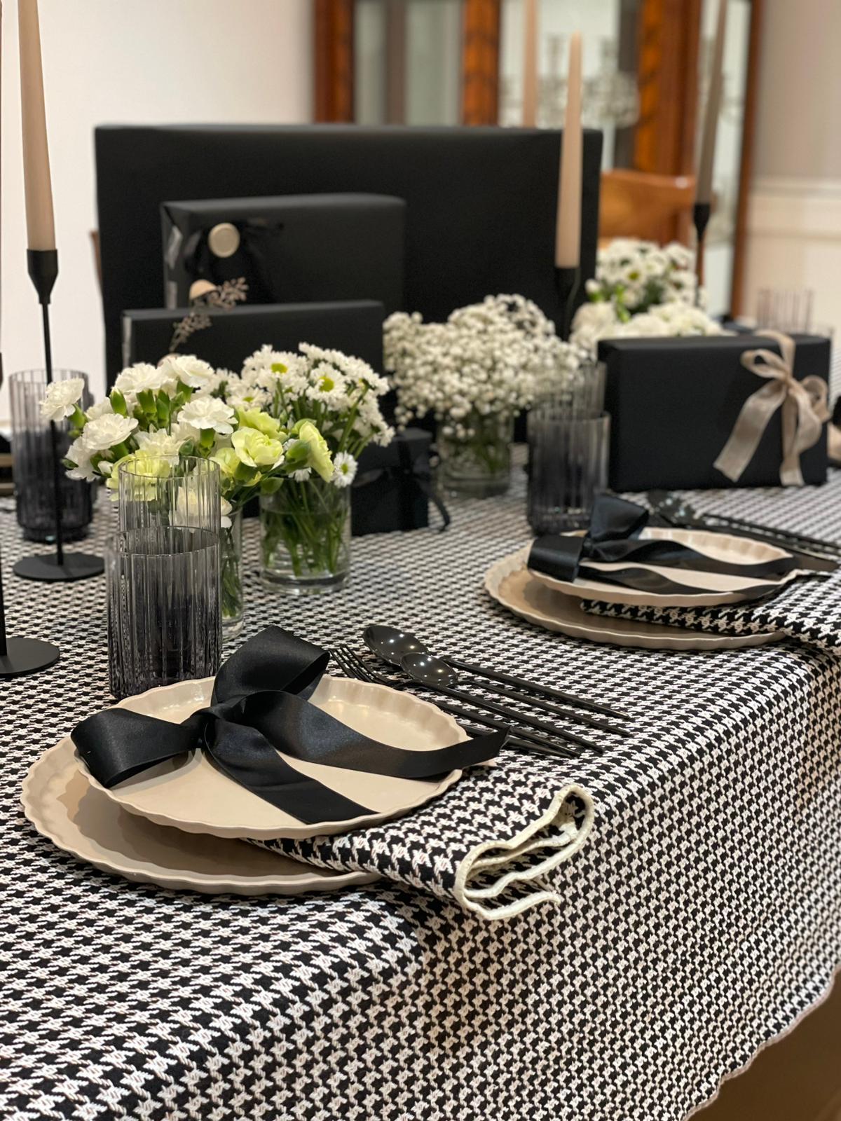 Beige and black houndstooth cloth napkin folded neatly on white surface