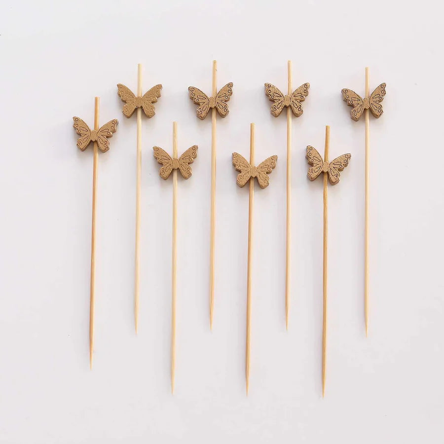 Colorful wooden cocktail picks with decorative ends arranged in a group